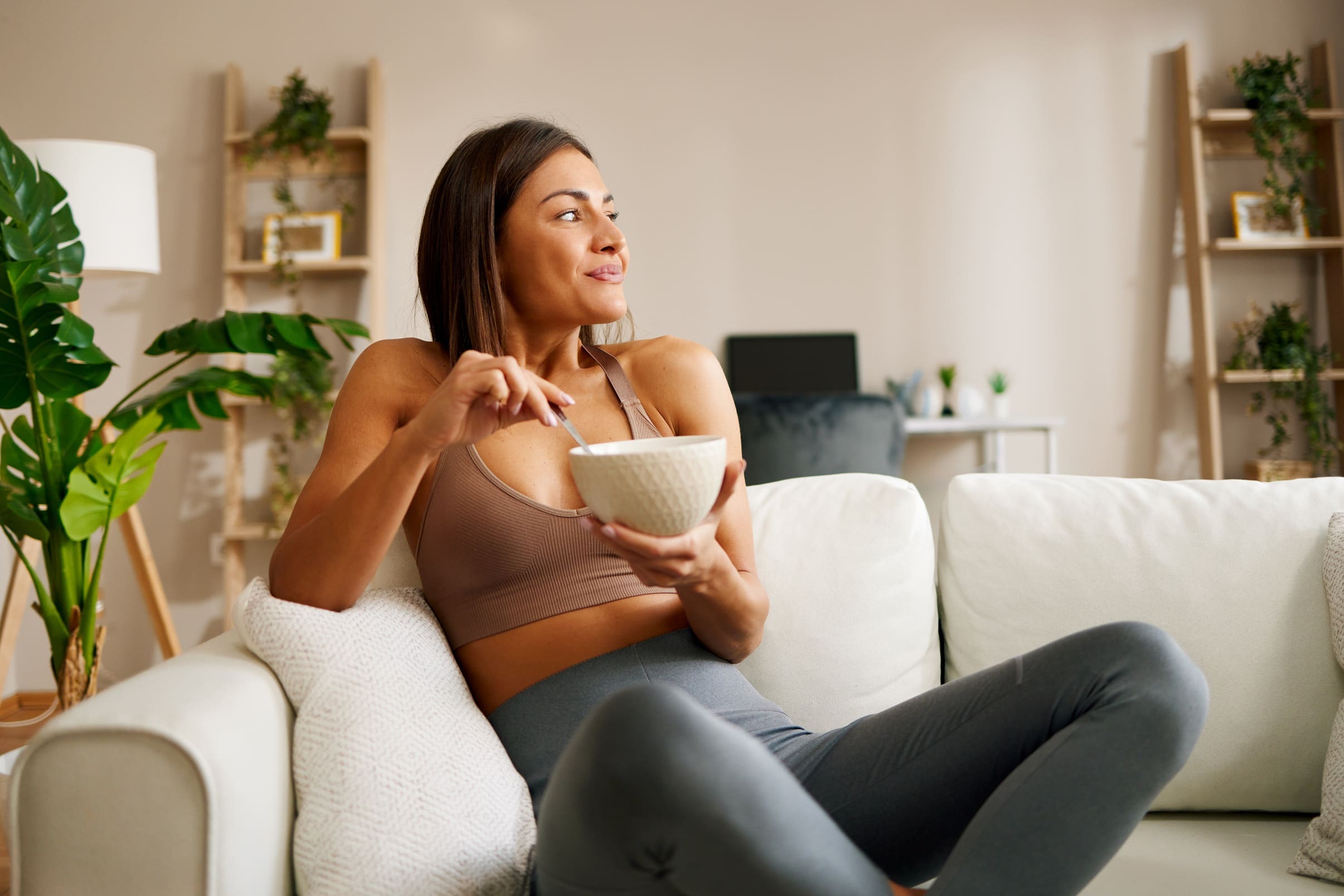 Healthy woman sitting on a sofa eating food